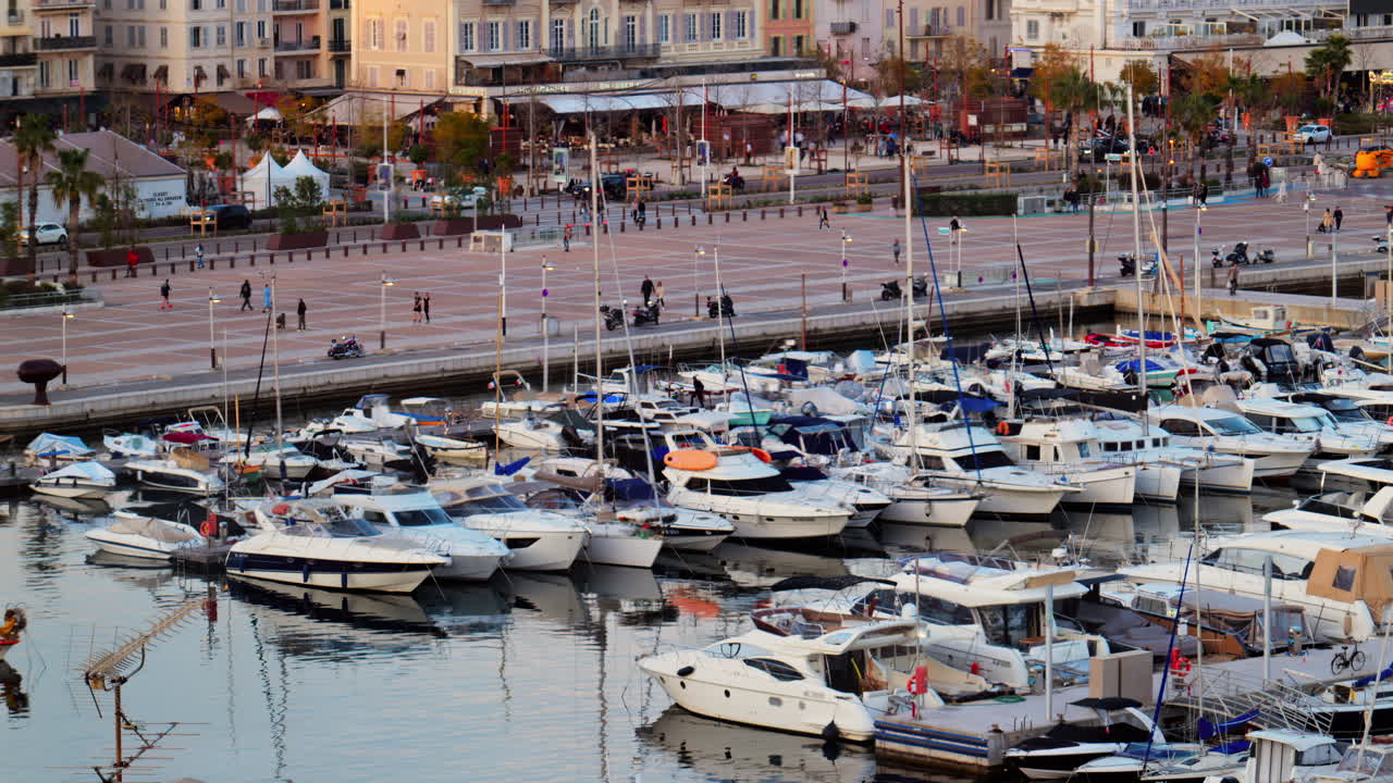 Cannes, France - March 15, 2025: View of multiple boats docked in the Cannes Marina with the buildings of the city on the background at sunset