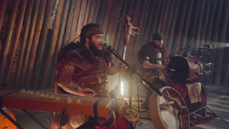 el líder de una banda folk toca un instrumento de arco cantando en ail