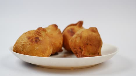 fried indian snacks on a white plate