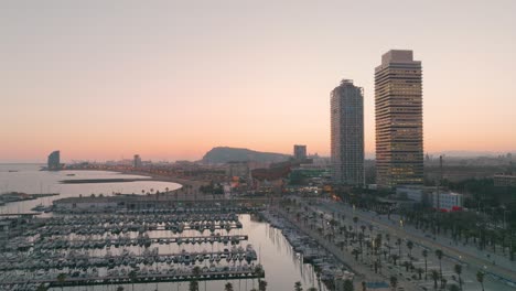 aerial view of modern buildings by the beach in barcelona during sunset. skyscrapers and boats in the sea port