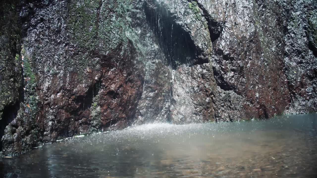 el agua de una cascada cae al estanque
