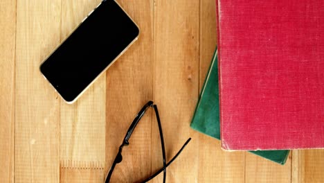 mobile phone with spectacles and books