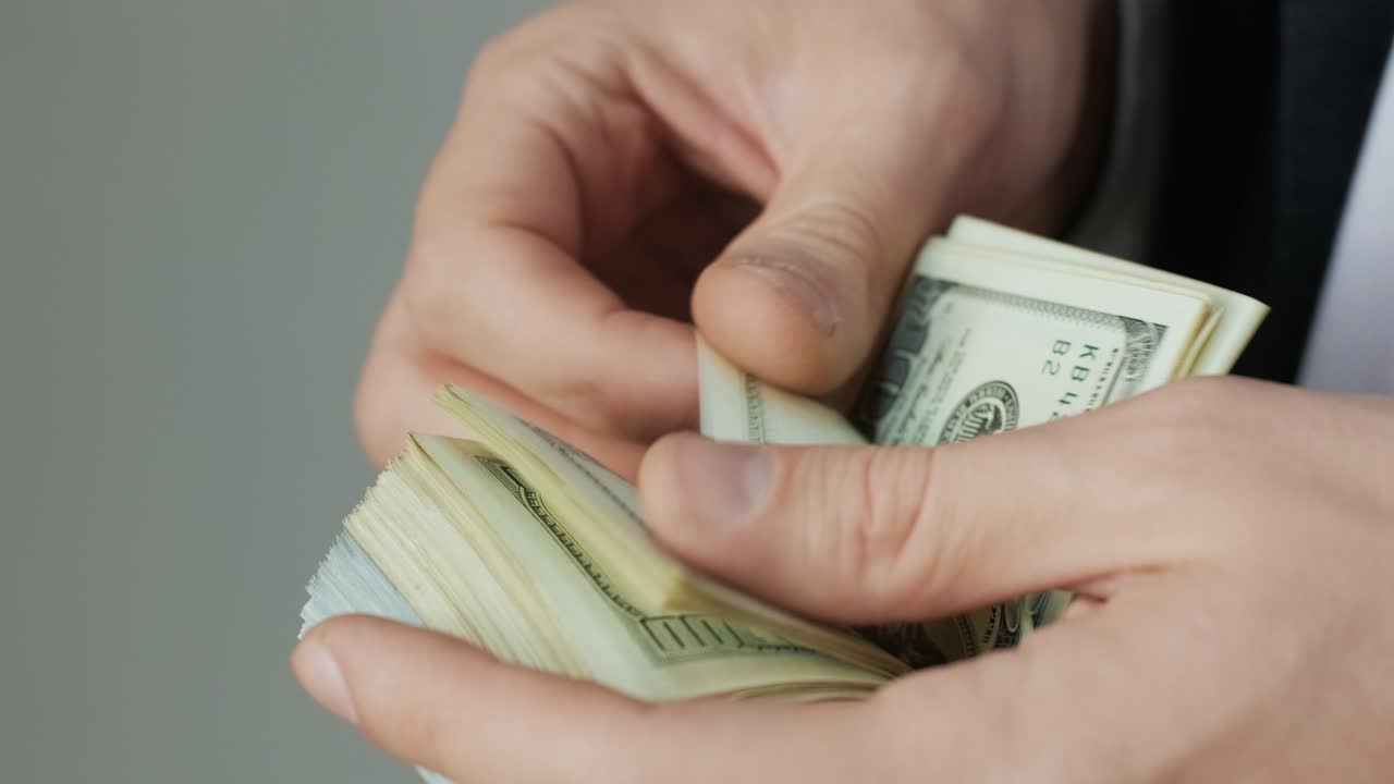 las manos de los hombres cuentan rápidamente los billetes. el hombre de negocios cuenta los dólares en las manos.