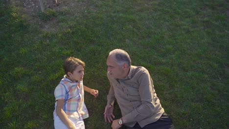 el niño le hace una pregunta a su abuelo.