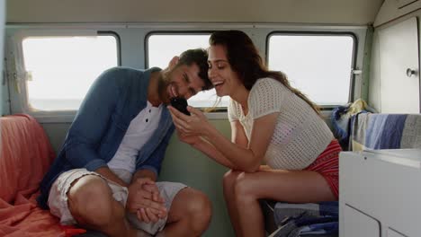 couple using mobile phone in camper van 4k