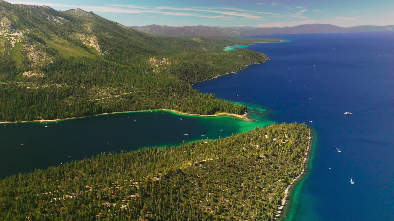 Splendid scenery of mountainous shore of the beautiful Lake Tahoe on sunny day. Green lake waterfront overgrown with pine trees. Top view.
