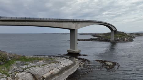 storseisundet bridge along the famous atlantic ocean road in norway - low altitude aerial approaching bridge and ocean passing below