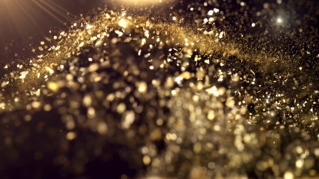 Particelle di polvere dorata scintillanti con raggi di luce su sfondo nero