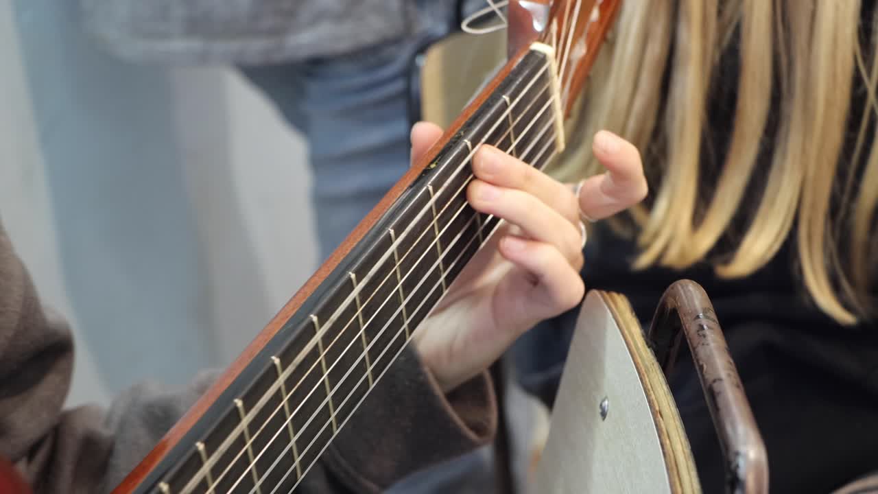 las hermosas manos de la joven que toca la guitarra es la musa que estaba viendo