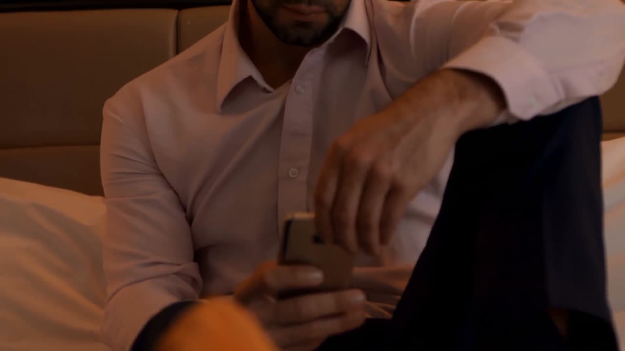 Forretningsmand bruger mobiltelefon i soveværelset 4K
