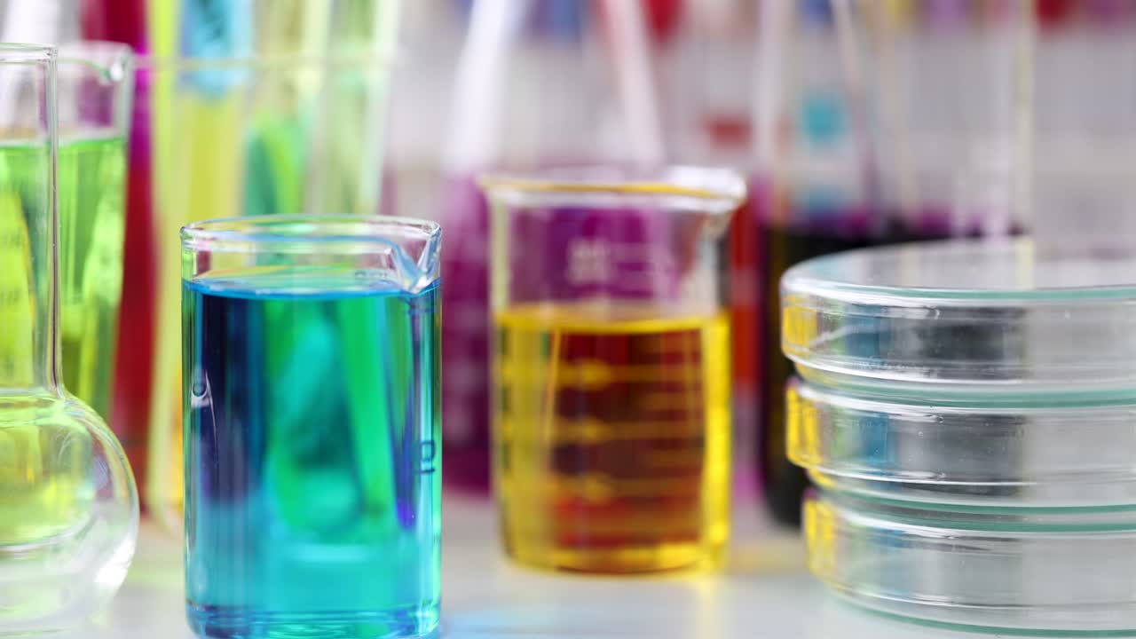 Vetreria chimica con liquido multicolore appoggiata su un tavolo in laboratorio