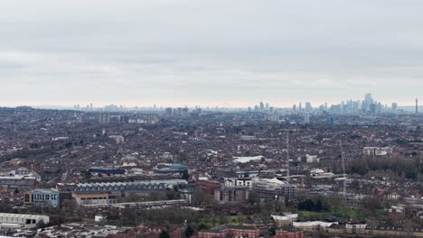 aerial view of wembley with city skyline in fog in distance. london borough of brent, england. sideways shot
