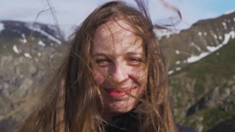 Slow motion shot of a woman enjoying the fresh wind atop Botev Peak, part of Bulgaria’s Stara Planina range. Her hair flows freely as she smiles, embodying joy and freedom in nature
