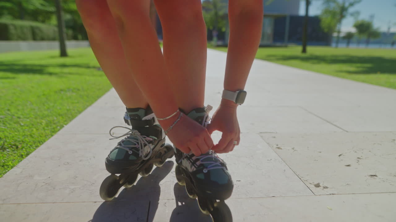 Woman lacing up roller skates in a park