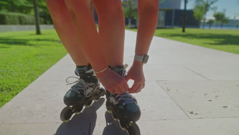 woman lacing up roller skates in a park