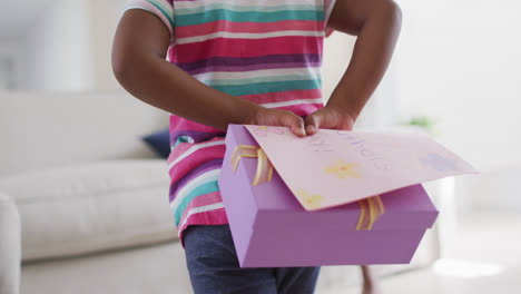 african american daughter giving mother gift on mother's day