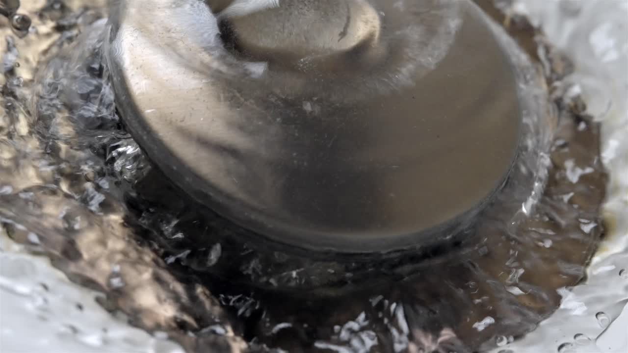 Close-Up of Running Water in Bathroom Sink Drain