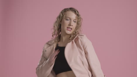 prise de vue en studio d'une jeune femme s'amusant à danser sur fond rose 2