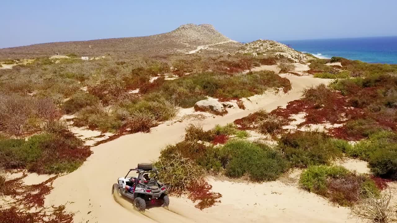 buenas imágenes aéreas sobre un vehículo todo terreno a toda velocidad a través de la arena en cabo san lucas baja mexico 1