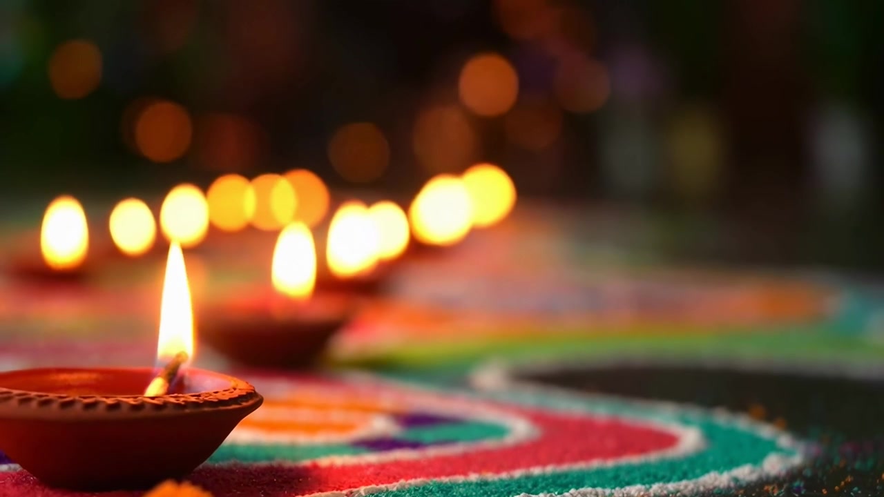 Lampade a olio in argilla tremolanti su Rangoli colorati per Diwali