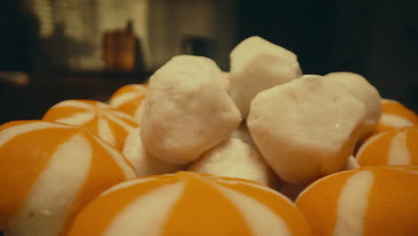 rotating plate filled with sweet white candy cubes and orange-striped treats