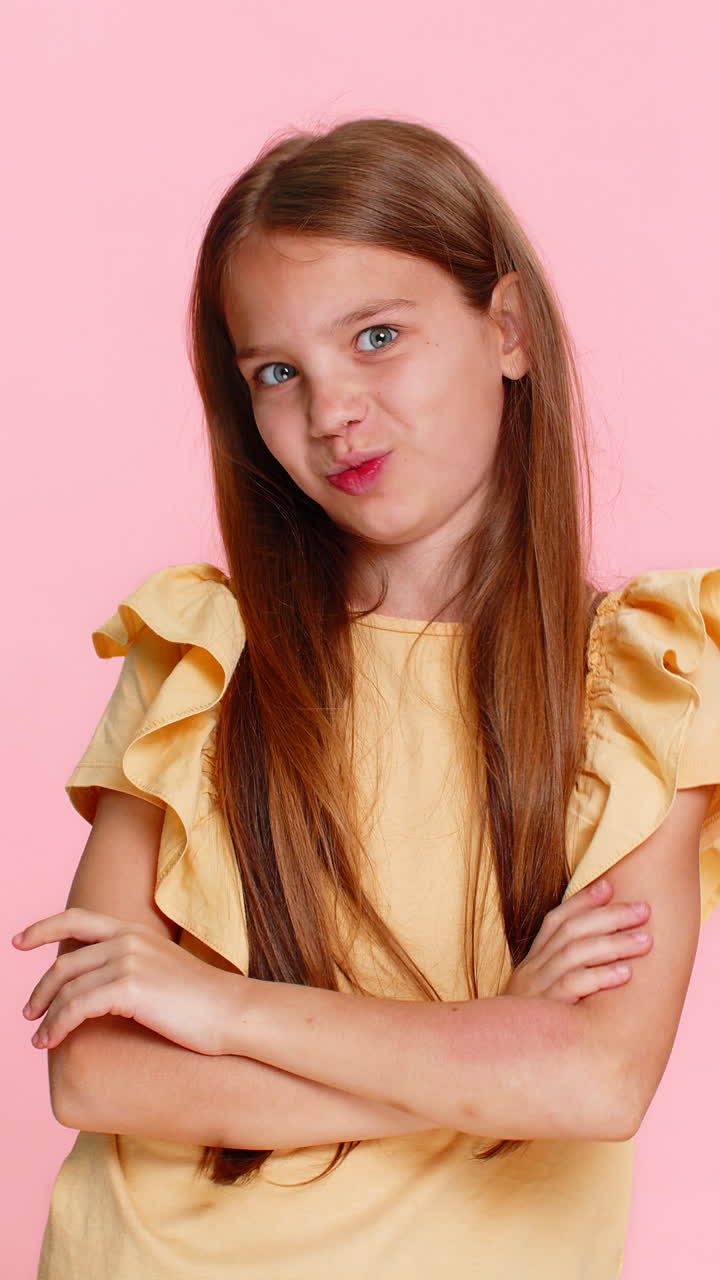 Child girl kid playfully teasing sticking out tongue at camera while making funny silly expressions