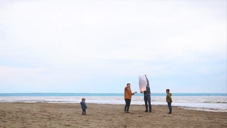 family launches sky lanterns on the beach