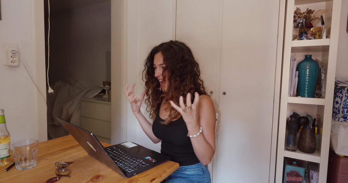 Una donna stressata affronta problemi mentre lavora al suo laptop a casa