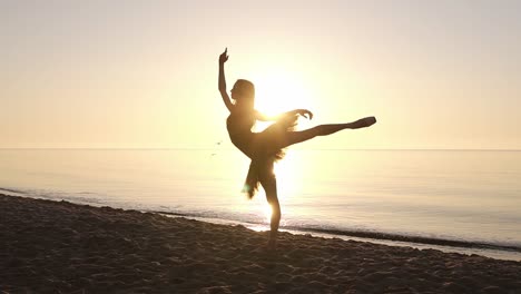 Silhouette-of-an-elegant-ballerina-in-a-tutu-in-the-rays-of-the-morning-sun.-Doing-exercises,-practicing.-Seashore.-Slow-motion