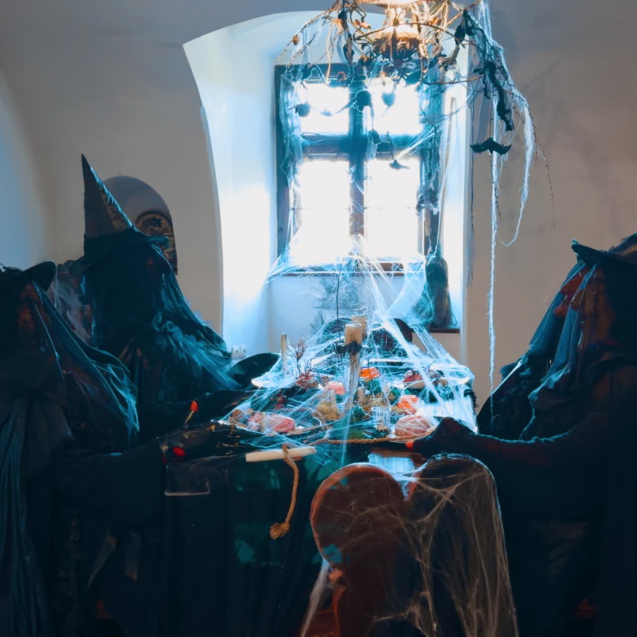 Går in i det lilla rummet med fyra figurer av fyra häxor som äter en festlig middag. Halloweendekoration i det gamla slottet