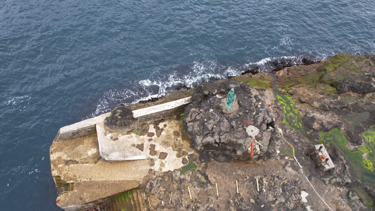 mikladalur costa rocosa vista superior con estatua de mujer foca en el borde del fiordo, isla kalsoy