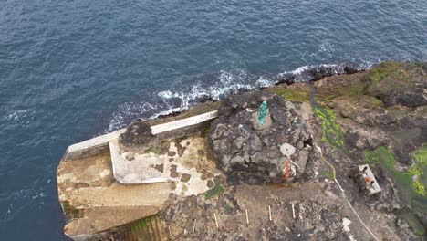 Mikladalur-rocky-coast-top-view-with-Seal-Woman-Statue-in-edge-of-fjord,-Kalsoy-Island