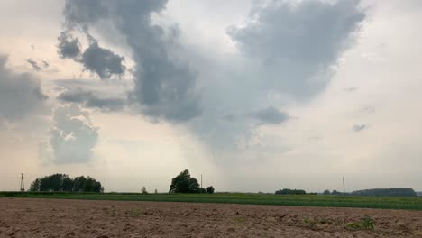 Beautiful,-Stunning-Clouds-Over-An-Agricultural-Field-In-Latvia---Timelapsed-Tilt-Up-Shot