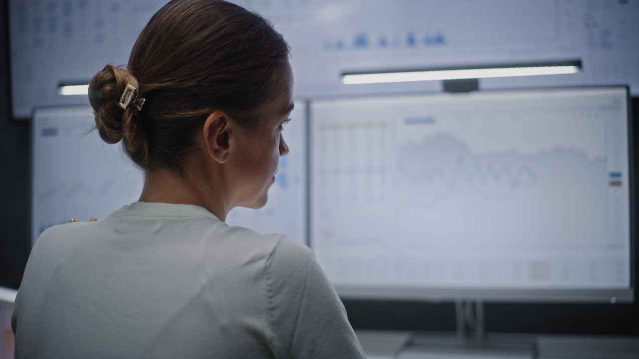 Female Stock Exchange Broker Monitoring Real-Time Stocks, Exchange Market Charts on Computer with Multi-Monitor Desktop Setup. Professional Investment Agent Working in Financial Agency Office at Night