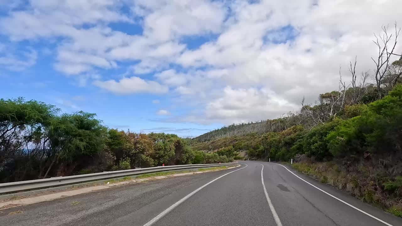 A 14-second video captures a scenic drive along the Great Ocean Road, showcasing lush greenery, coastal views, and winding roads