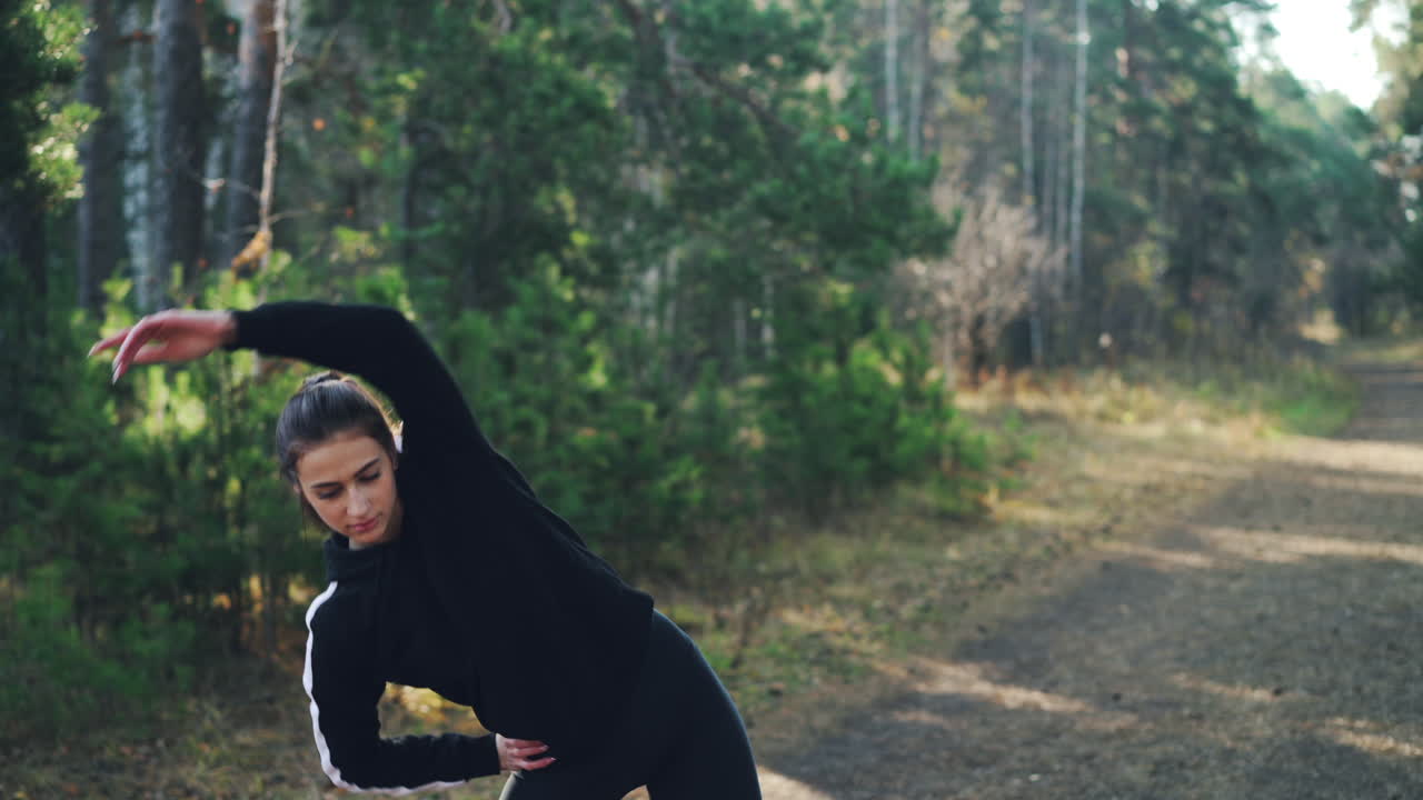 mujer estirándose en el bosque