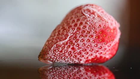 focusing one frozen strawberry, with reflection, macro close up