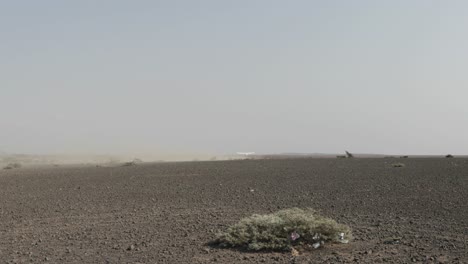 Liftoff-of-propeller-plane-lifting-from-a-dirt-runway-in-Kenya-East-Africa,-Handheld-low-shot