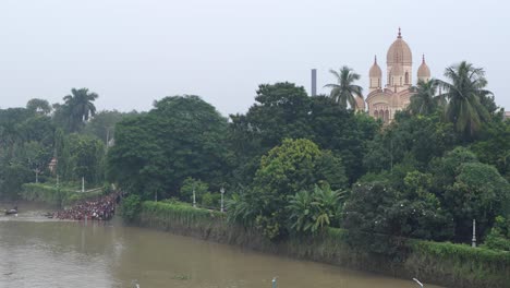 gathering of people and tarpan at dakshineswar temple in kolkata on mahalaya day on the eve of durga puja.