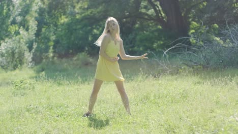 happy beautiful young girl dancing of freedom in summer park with trees in the background.