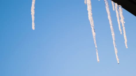 hielos colgando de un techo contra un cielo azul