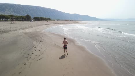 man jogging on the beach alone