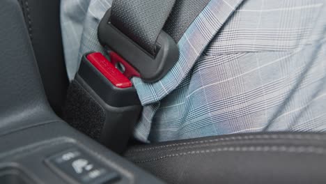 person fastening a car seatbelt