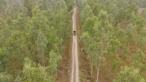 Toma-De-Drone-De-Un-Camión-Que-Viaja-Dentro-Del-Bosque-Verde-De-La-Región-De-Terai-De-Nepal-A-Katmandú