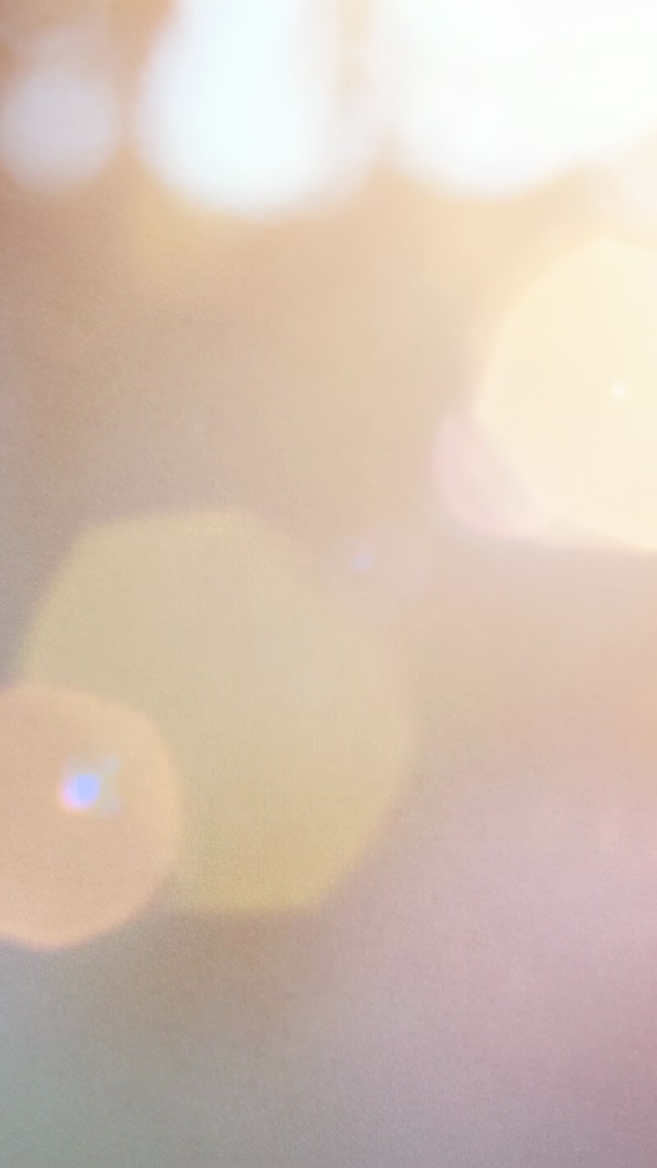 Vídeo vertical: Bokeh e reflexos de lente em movimento com o sol passando através das folhas ao ar livre
