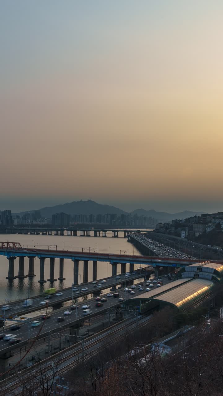 Hyperlapse aereo verticale di traffico intenso sull'autostrada Gangbyeonbuk-ro e il Ponte Dongho con il disco solare che tramonta sul distretto di Hannam a Seul, Corea del Sud