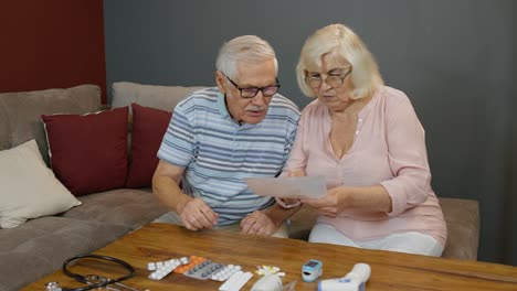 elderly couple looking at prescription and medicine