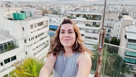 young woman vlogging from a rooftop overlooking athens