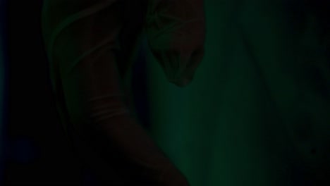 primer plano de guantes médicos iluminados por luz verde