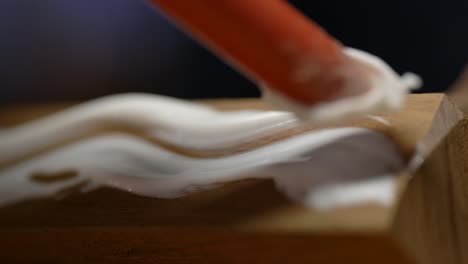 macro shot of carpenter glueing wood with glue, furniture manufacturing industry